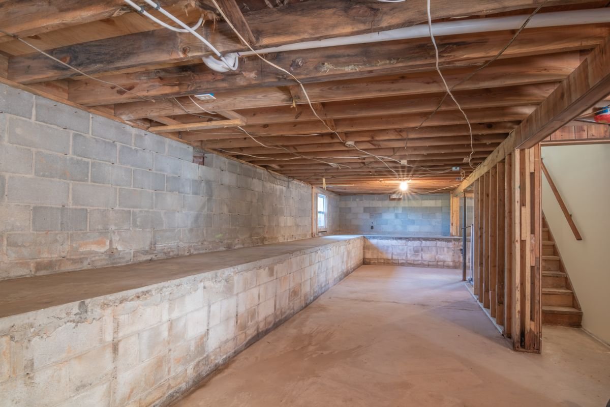 Unfinished basement interior with concrete walls ready for waterproofing